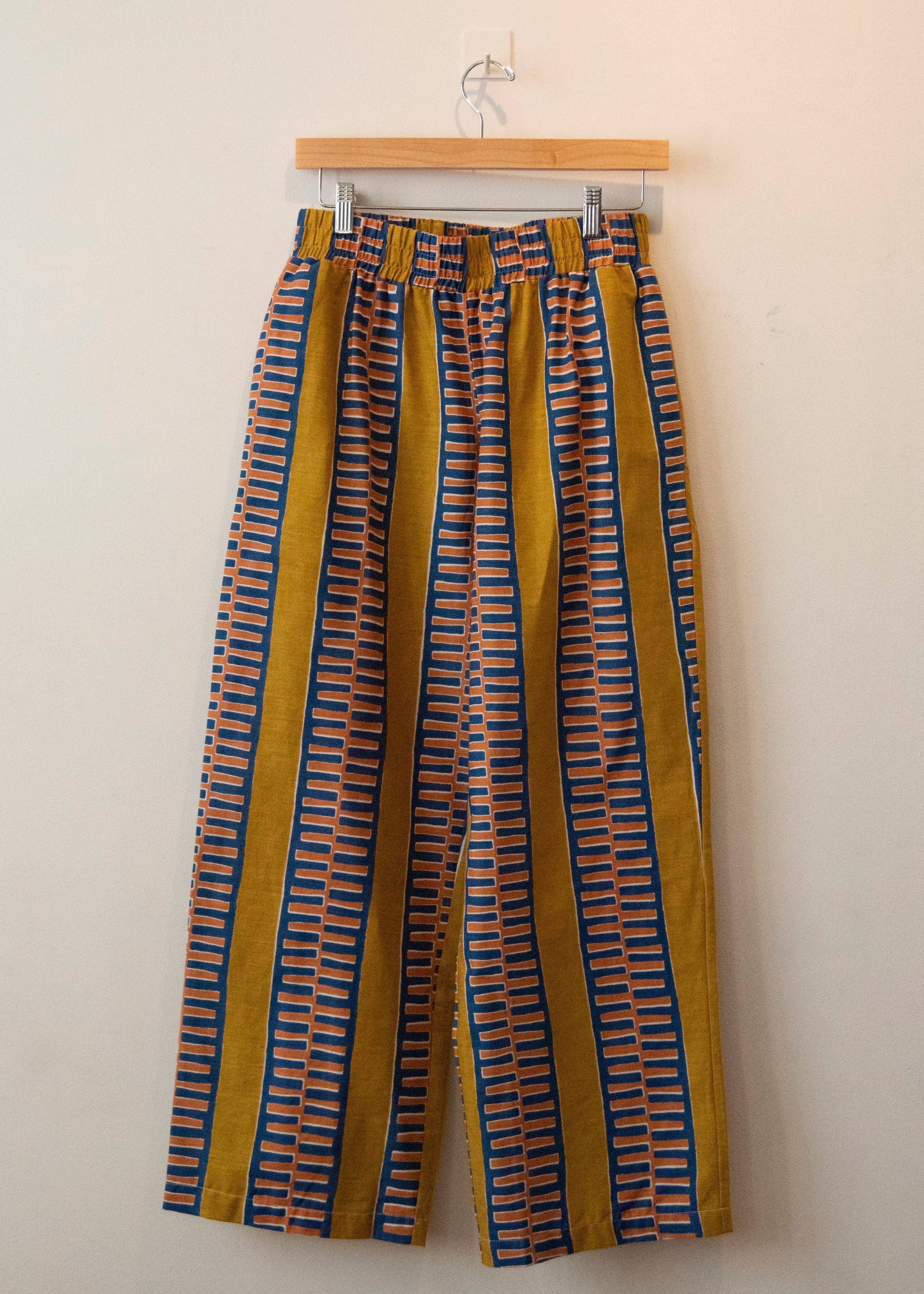 Display of yellow pants with blue zig zag pattern.
