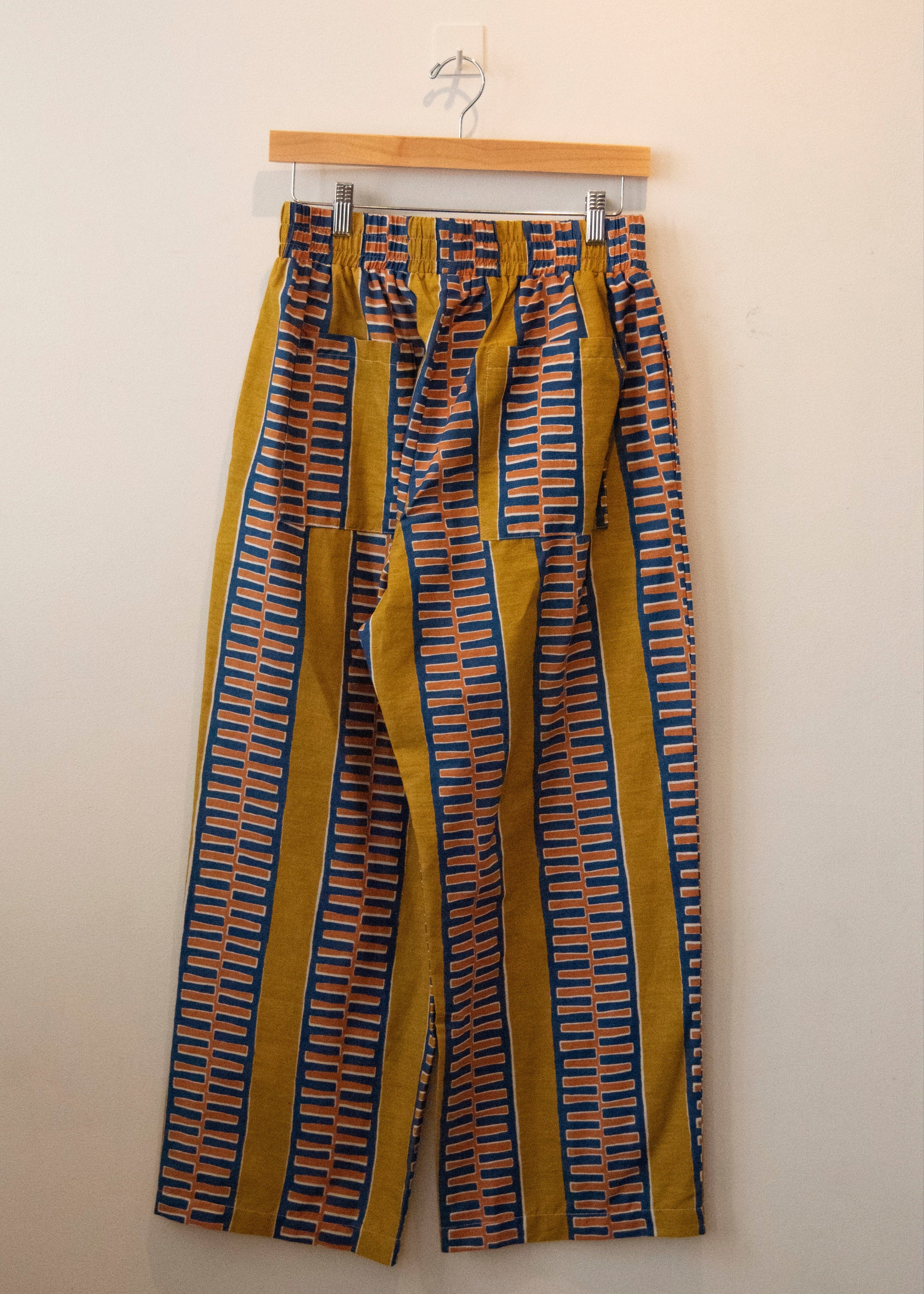 Display of yellow pants with blue zig zag pattern.
