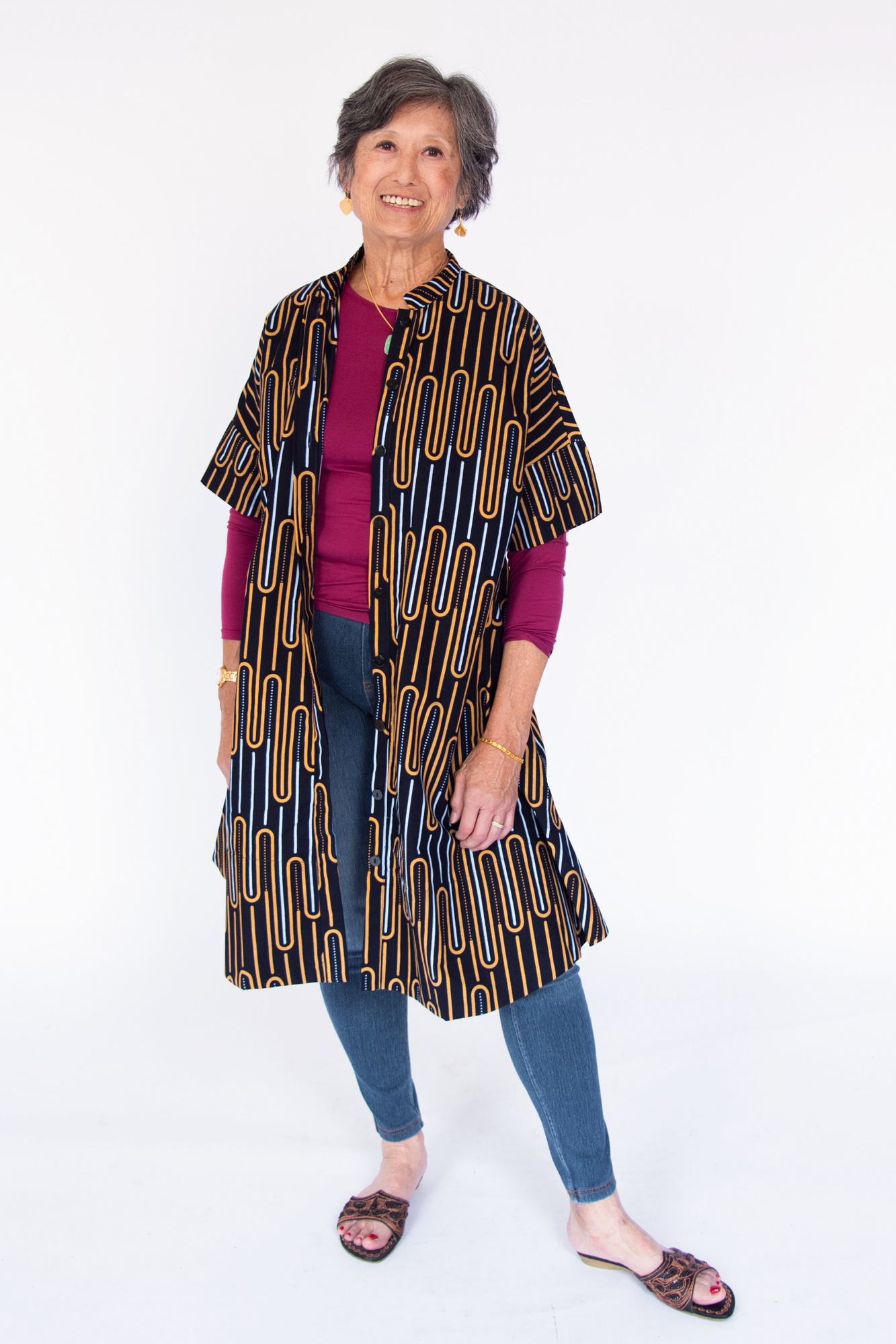 Model wearing deep navy dress with yellow and gold geometric lines.