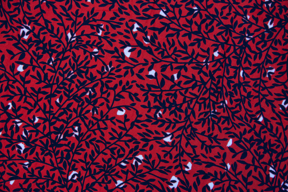 Close up display of red dress with black and white vine print, fabric.