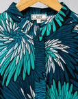 Display of turquoise, black, pacific blue, slate and white feathered spiral print dress