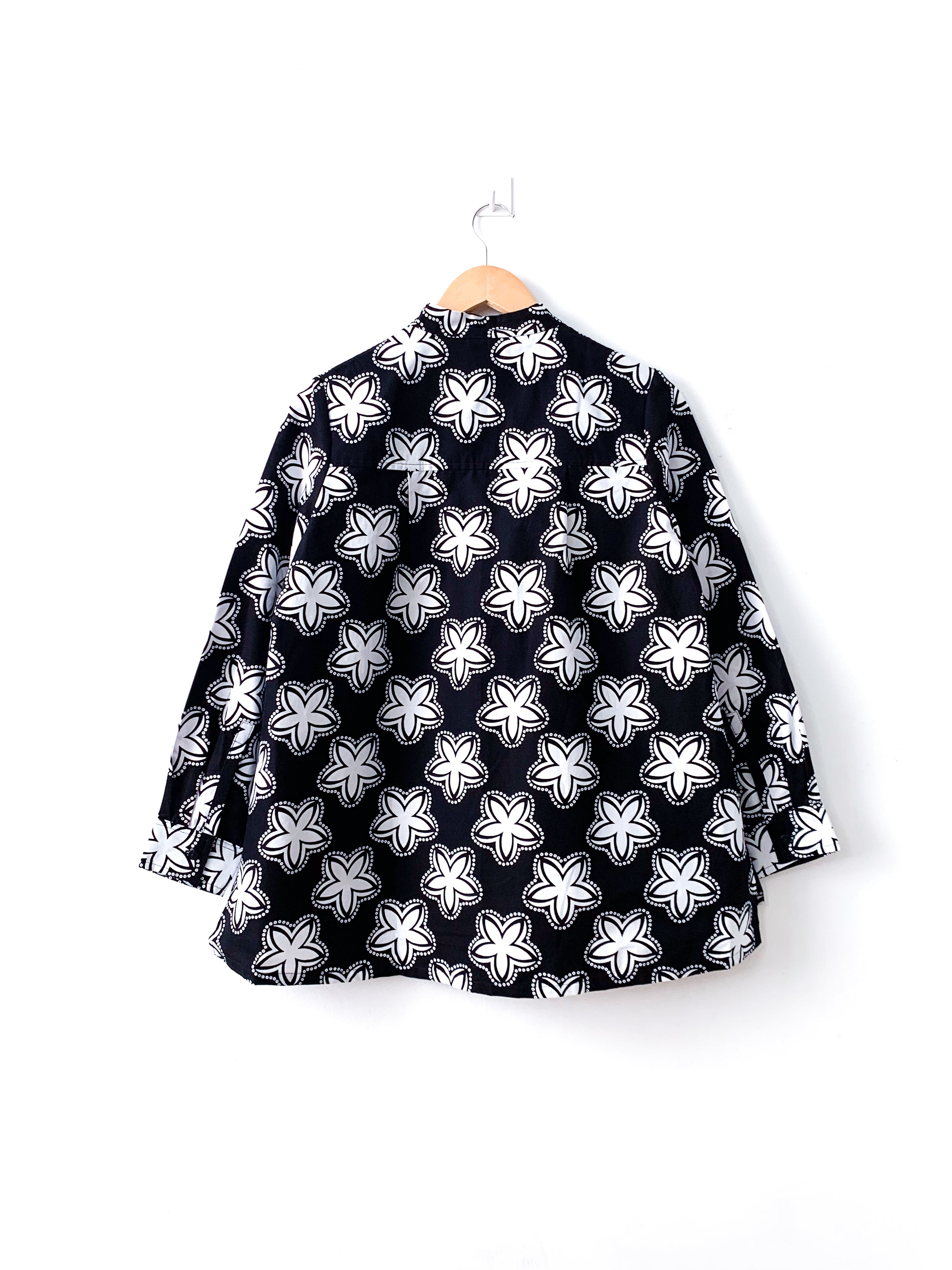 Display of black and white shirt with floral print.