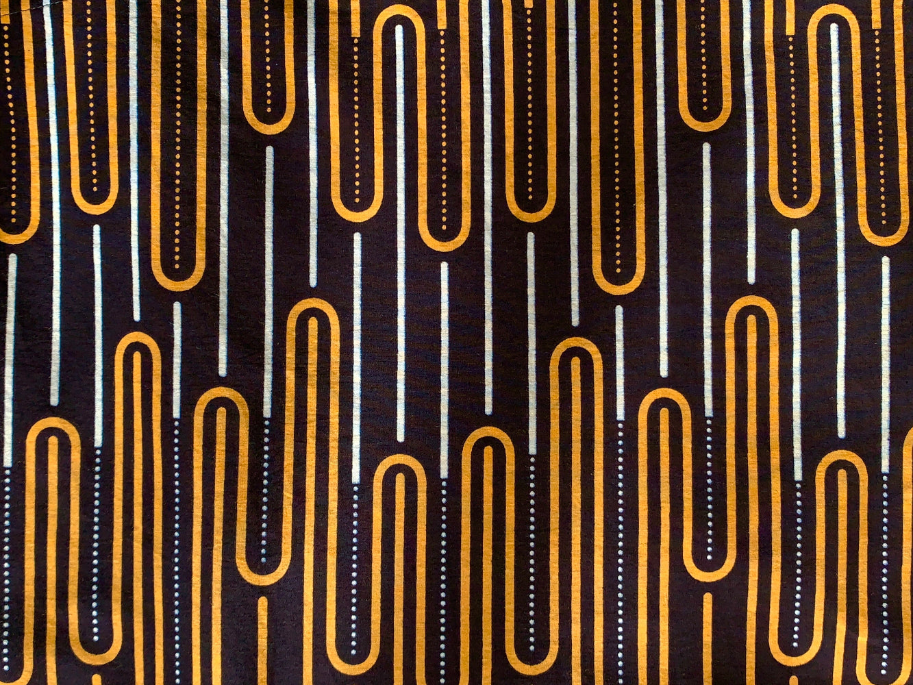Close up display of sleeveless shirt with yellow and white geometric print, fabric.