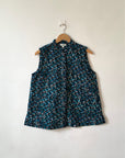 Display of blue, black and white abstract print sleeveless shirt. 