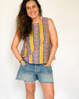 The model is wearing olive-yellow, blue, orange and white geometric printed  tank