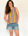 The model is wearing olive-yellow, blue, orange and white geometric printed  tank