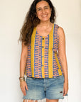 The model is wearing olive-yellow, blue, orange and white geometric printed  tank