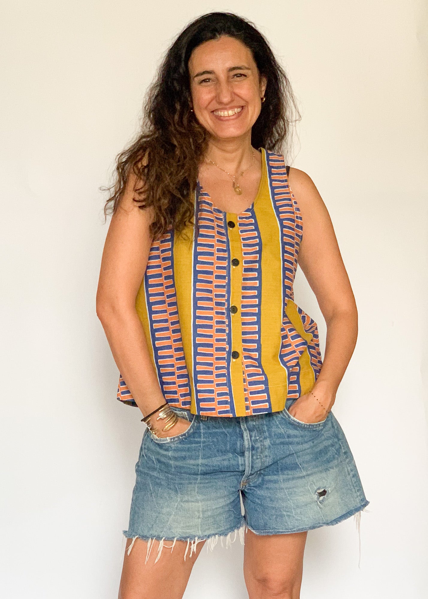 The model is wearing olive-yellow, blue, orange and white geometric printed  tank