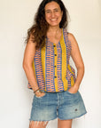 The model is wearing olive-yellow, blue, orange and white geometric printed  tank