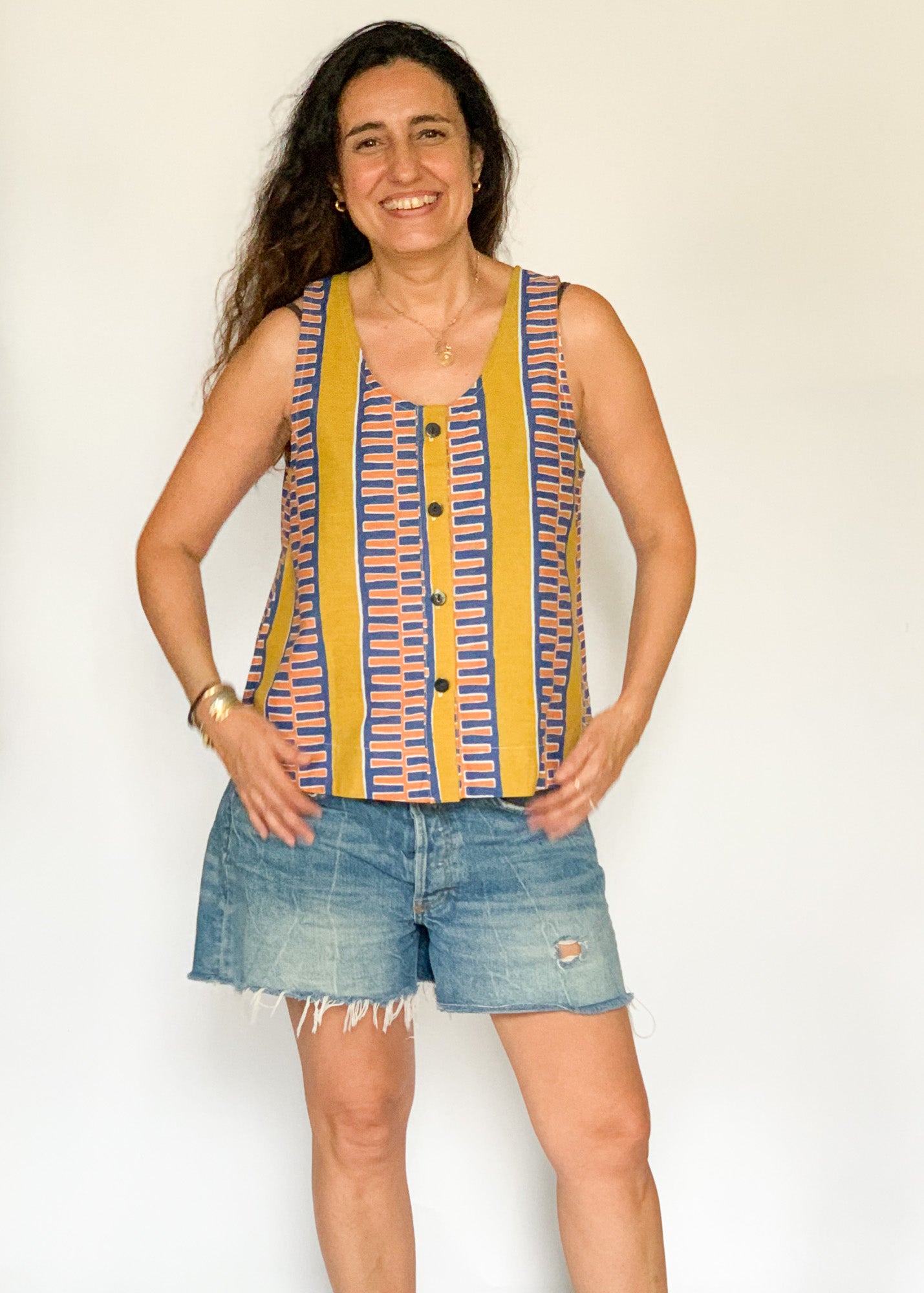 The model is wearing olive-yellow, blue, orange and white geometric printed  tank