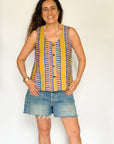 The model is wearing olive-yellow, blue, orange and white geometric printed  tank