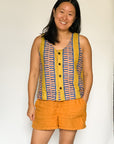 The model is wearing olive-yellow, blue, orange and white geometric printed  tank