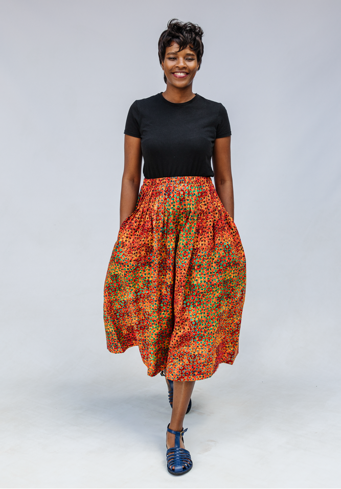 Model wearing multicolored dot print skirt.