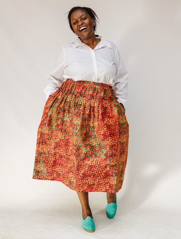 Model wearing multicolored dot print skirt.