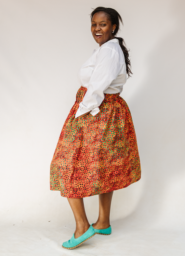 Model wearing multicolored dot print skirt.