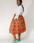 Model wearing multicolored dot print skirt.