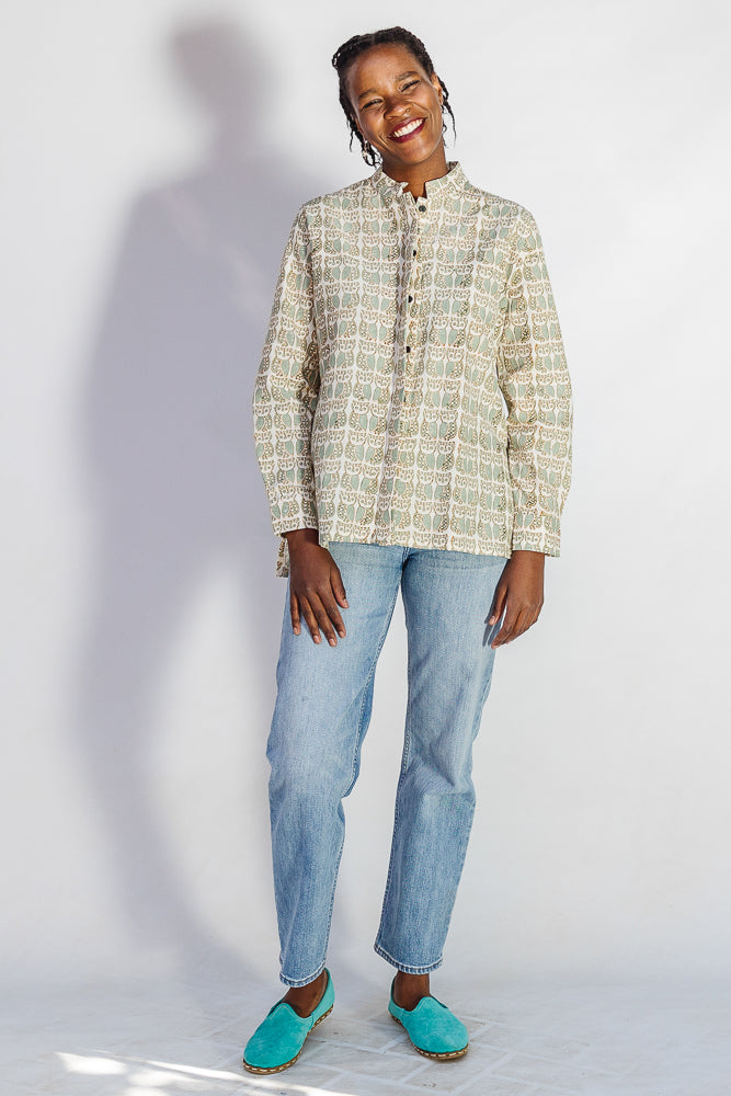 Model wearing long sleeved shirt with small owl print.