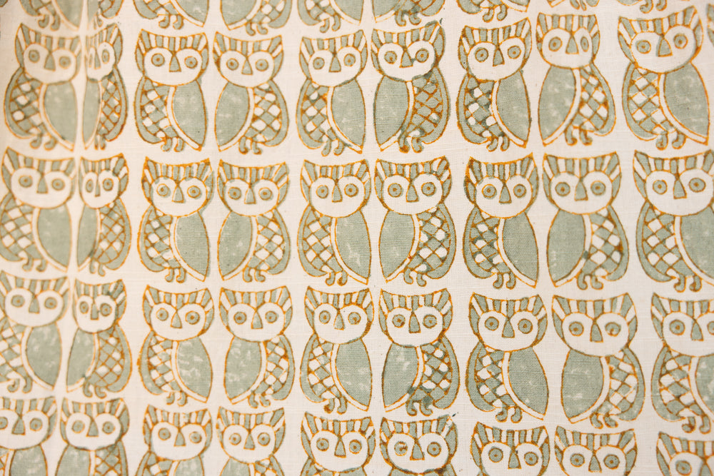 Close up display of long sleeved shirt with small owl print, fabric.