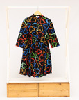 Display of black dress with multicolored heart print pattern.
