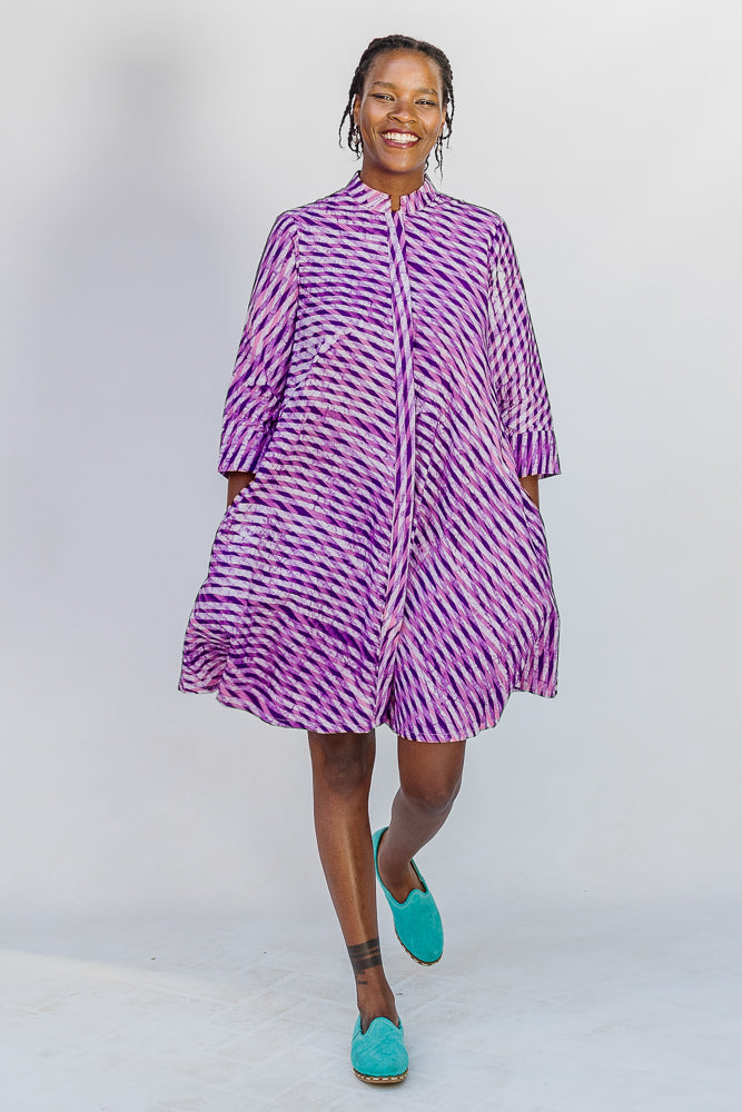 Model wearing purple and pink plaid batik dress.