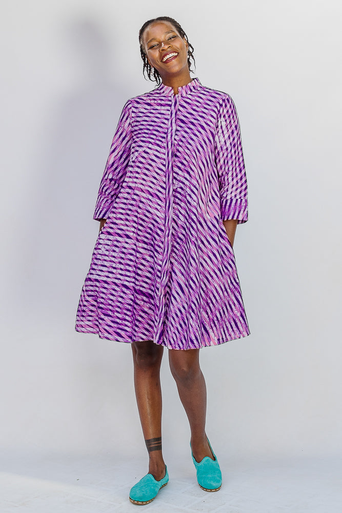 Model wearing purple and pink plaid batik dress.
