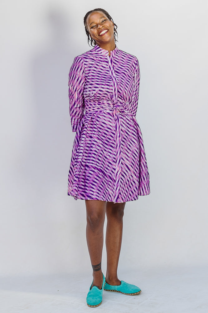 Model wearing purple and pink plaid batik dress.