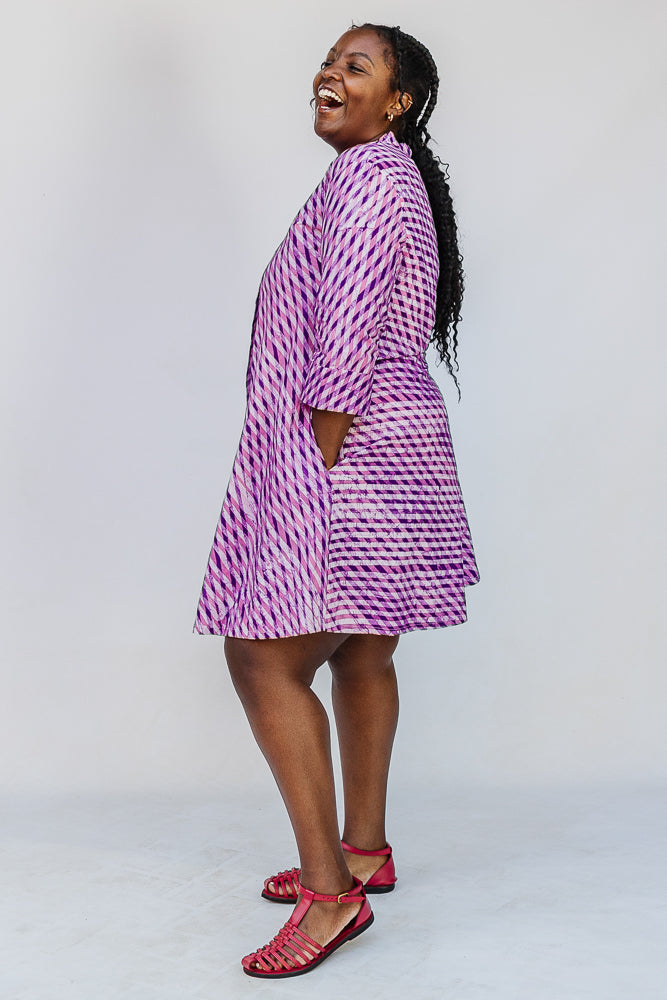 Model wearing purple and pink plaid batik dress.