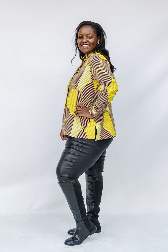 Model wearing yellow, brown and white abstract print shirt.