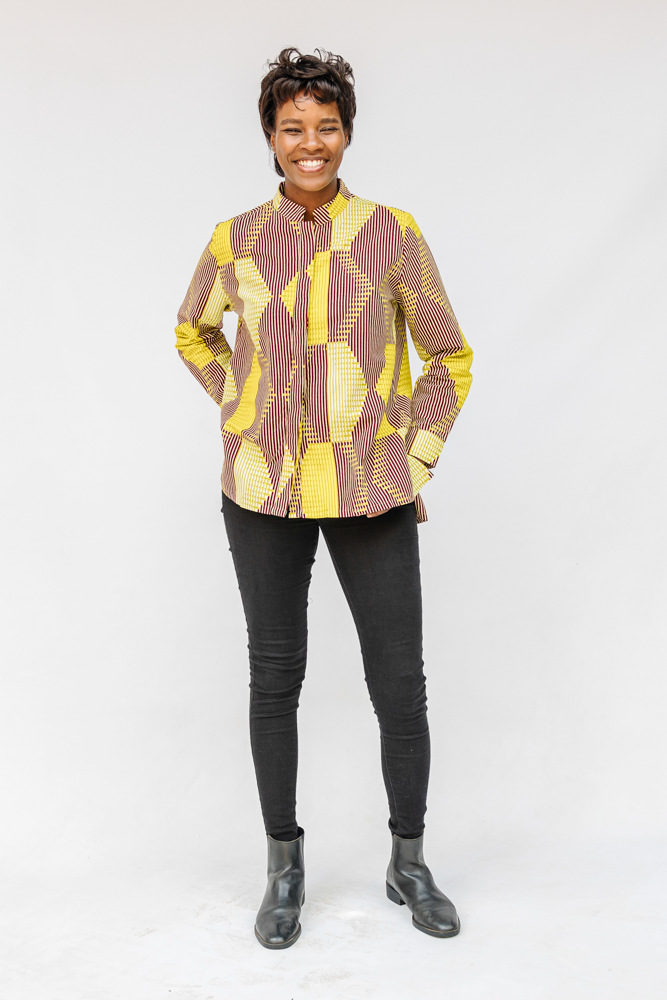 Model wearing yellow, brown and white abstract print shirt.