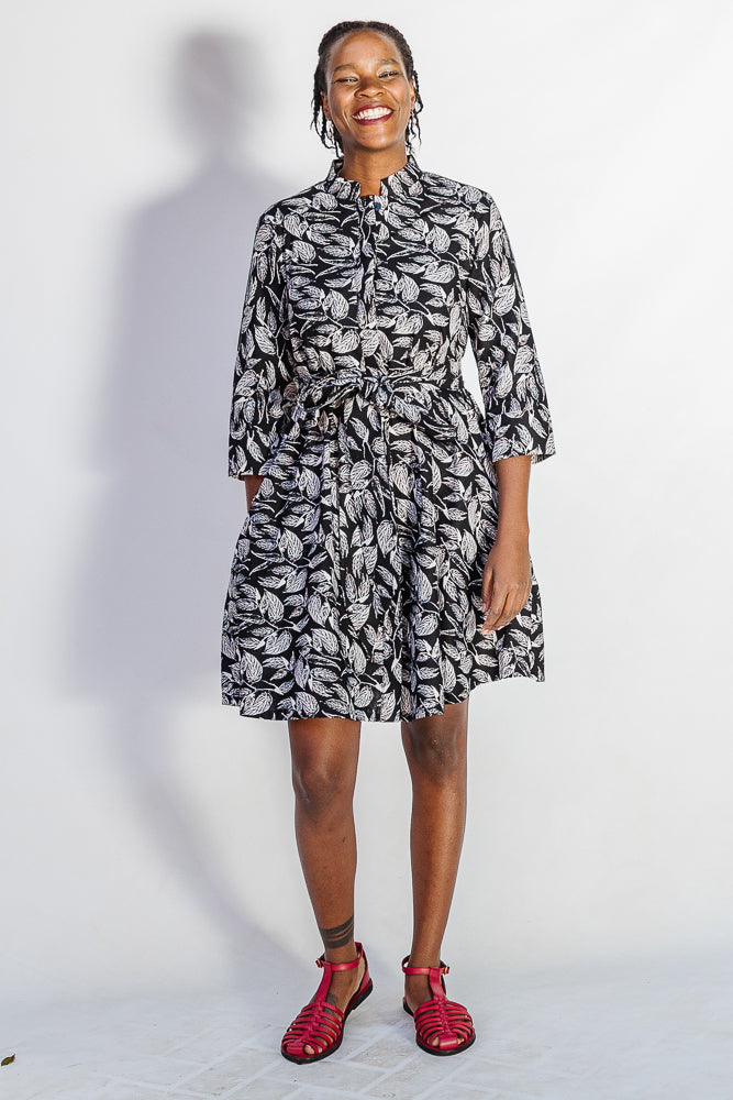 Model wearing black and white leaf print dress.