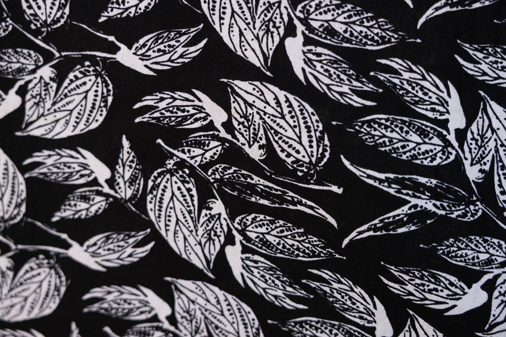 Close up display of black and white leaf print dress, fabric.
