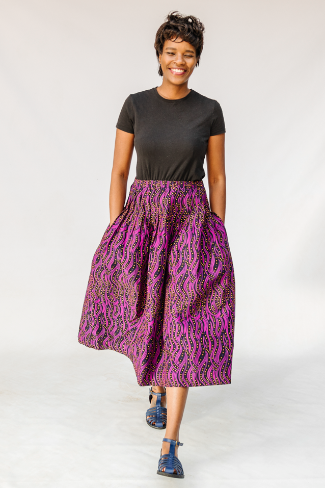 Model wearing fuchsia skirt with small dot design.