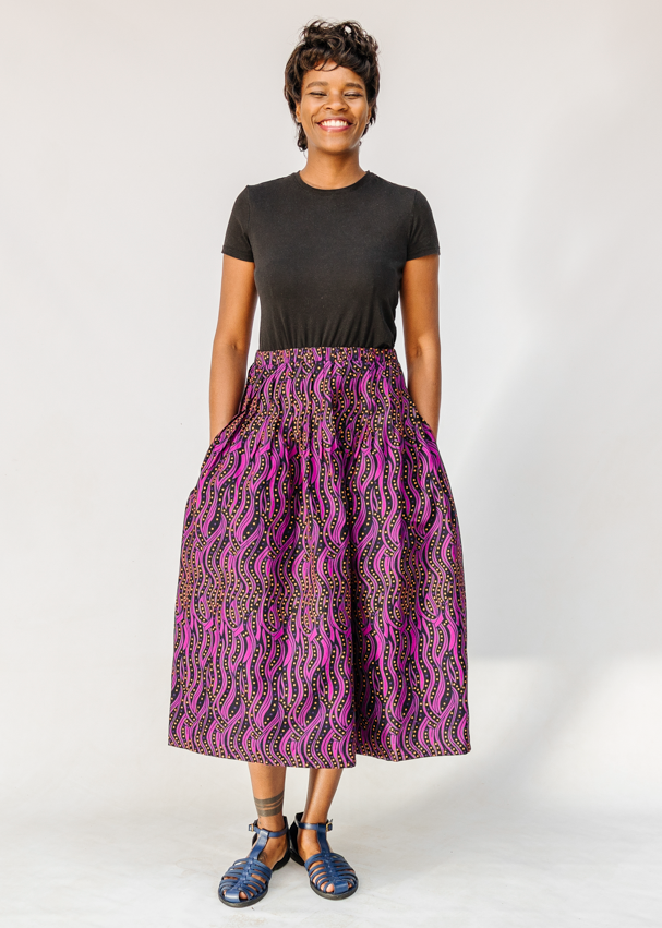 Model wearing fuchsia skirt with small dot design.