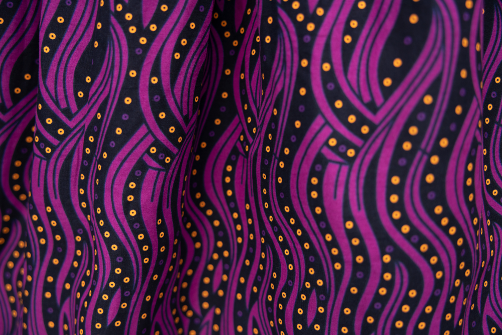 Close up display of fuchsia skirt with small dot design, fabric.