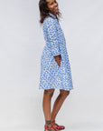 Model wearing blue dress with white polka dots.