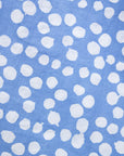 Close up display of blue dress with white polka dots, fabric.