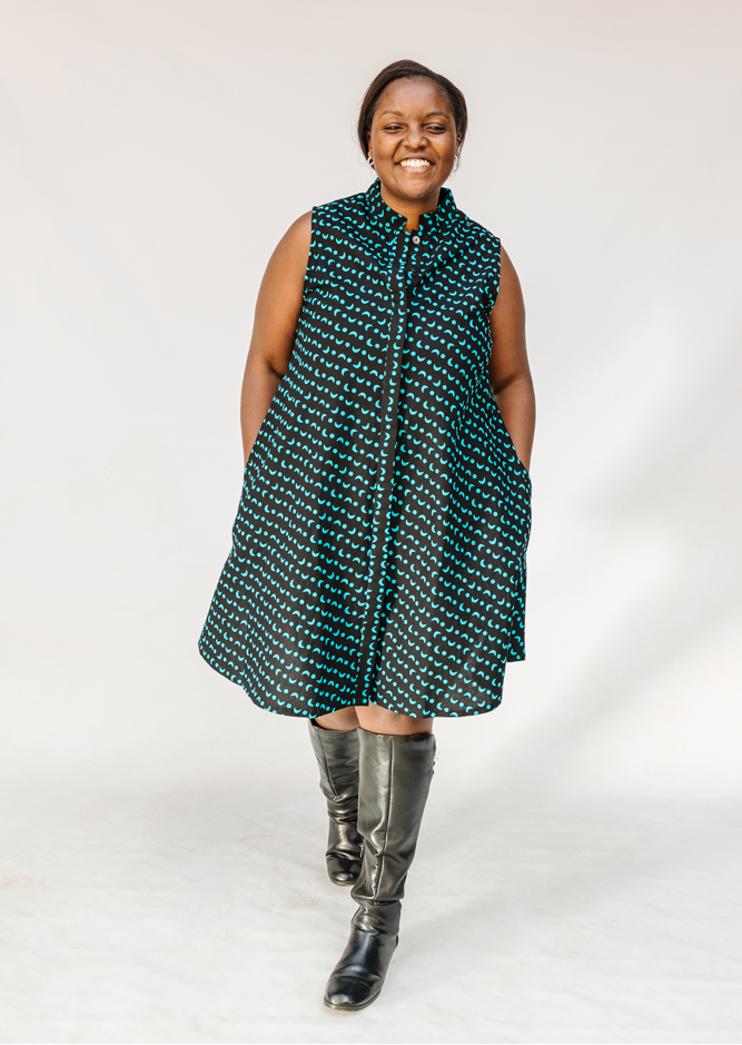 Model wearing sleeveless black dress with teal moon design.