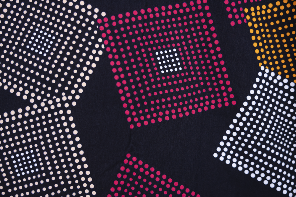 Close up display of pink, orange, white and black maxi dress, fabric.