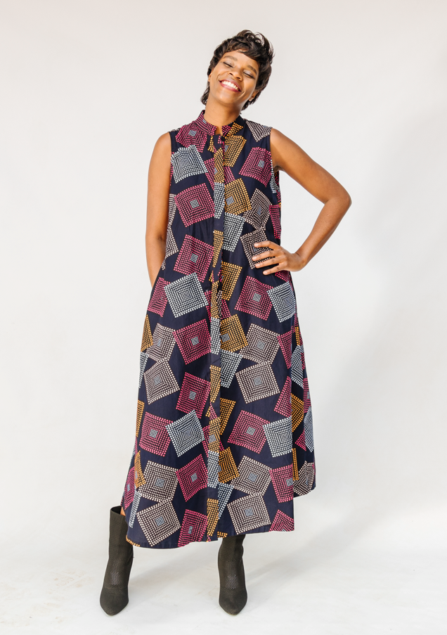 Model wearing pink, orange, white and black geometric print dress.