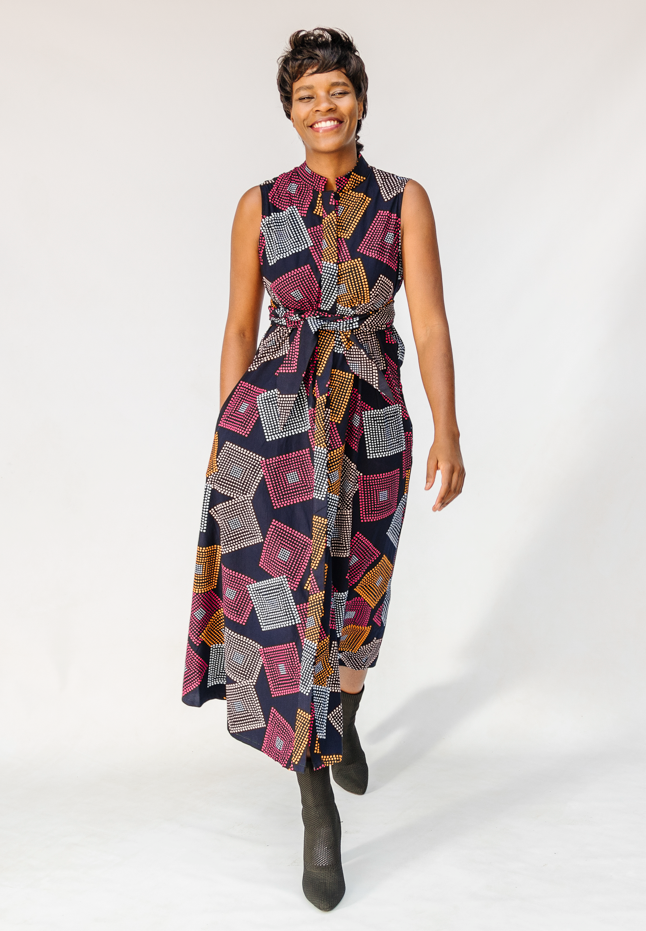 Model wearing pink, orange, white and black geometric print dress.