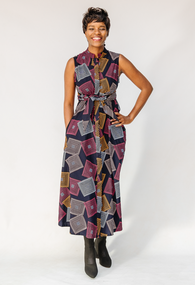 Model wearing pink, orange, white and black geometric print dress.