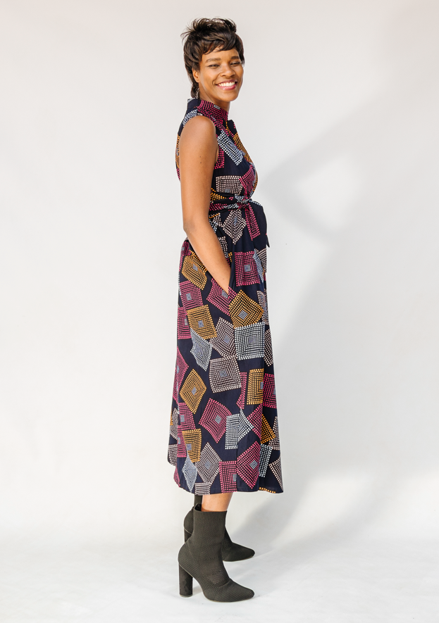 Model wearing pink, orange, white and black geometric print dress.