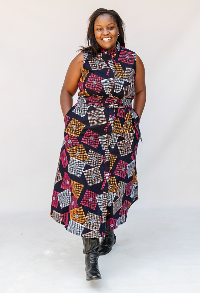 Model wearing pink, orange, white and black geometric print dress.