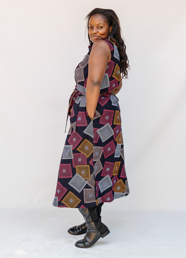 Model wearing pink, orange, white and black geometric print dress.