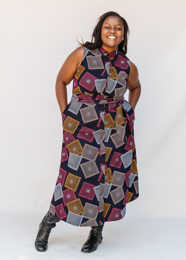 Model wearing pink, orange, white and black geometric print dress.