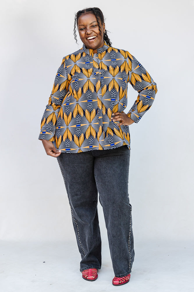 Model wearing of blue, white and yellow abstract print shirt.