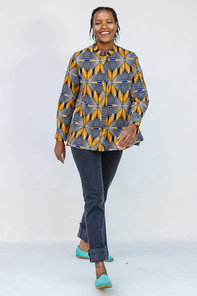 Model wearing of blue, white and yellow abstract print shirt.