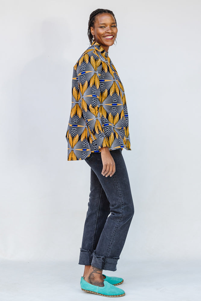 Model wearing of blue, white and yellow abstract print shirt.