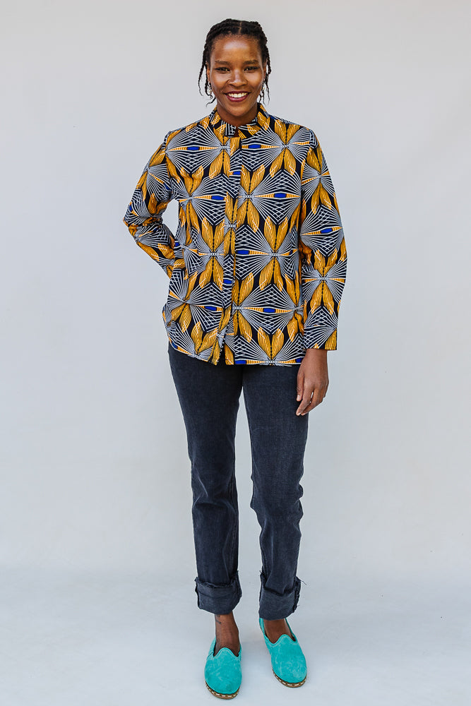 Model wearing of blue, white and yellow abstract print shirt.