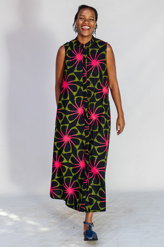 Model wearing navy and green dress with pink floral print.